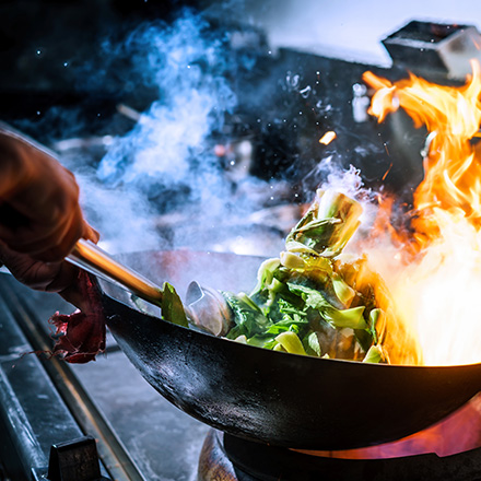 Poêle dans laquelle est cuit un sauté de légumes 